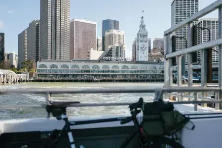 Bike leaning against a rail with the Ferry Building in the background.