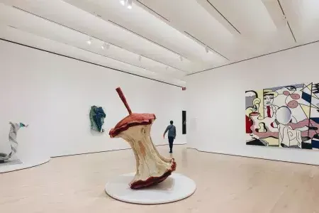 A man walks through a large, airy exhibit room filled with modern art at SFMOMA. San Francisco, California.